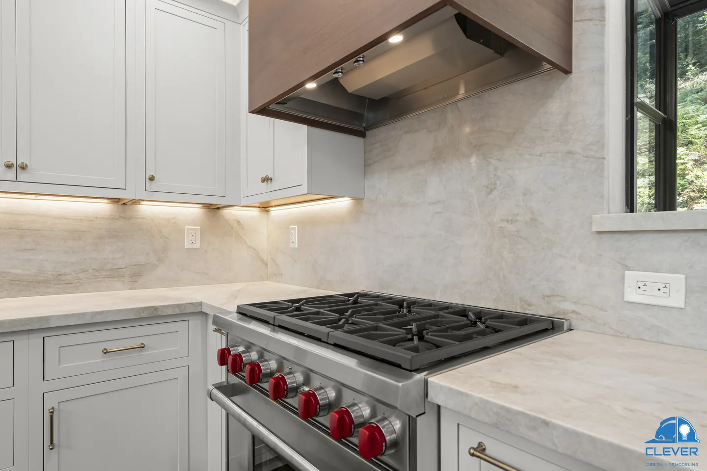 Range wall with a walnut hood, under-cabinet lighting and a full-height stone backsplash, kitchen and bath remodel in Los Gatos, CA