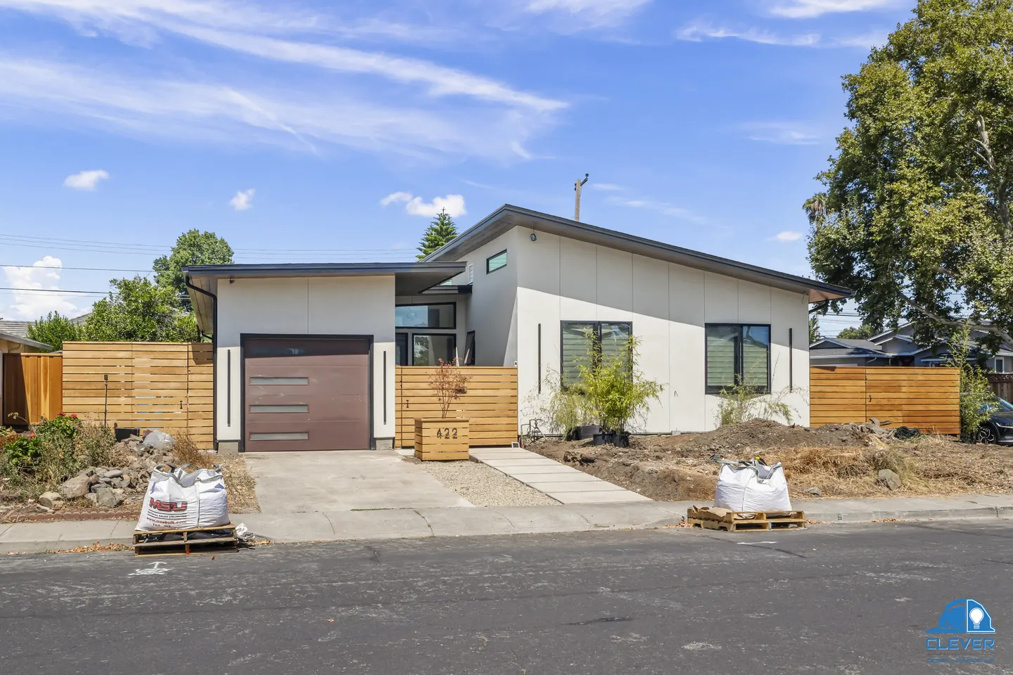 Street view of the home with offset shed roofs, black-framed windows and a cedar fence, modern home in Santa Clara, CA