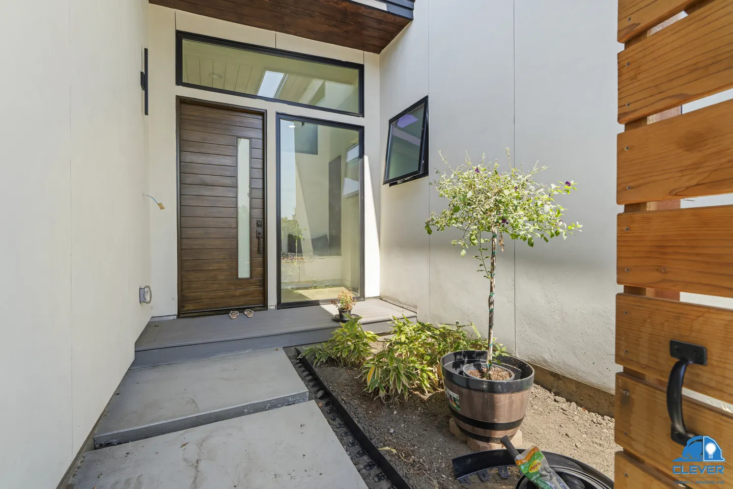 Covered entry with a wood plank front door, a glass sidelight and a transom, modern home in Santa Clara, CA