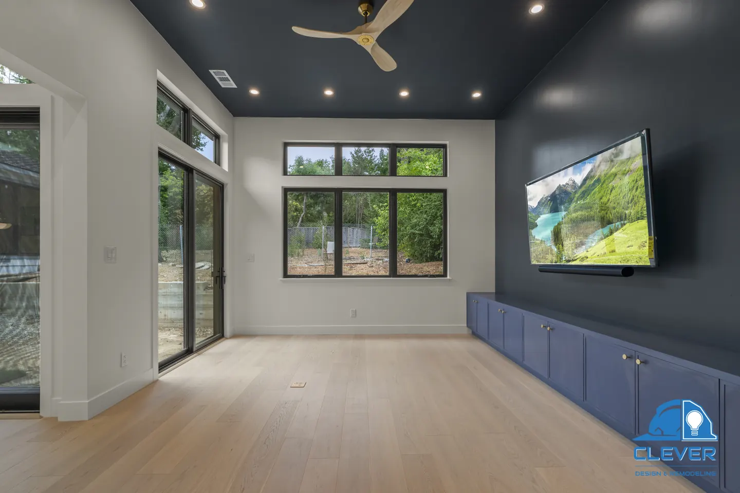Media room with a navy ceiling and accent wall, built-in navy cabinets and black-framed sliding doors, whole-home remodel in Saratoga, CA