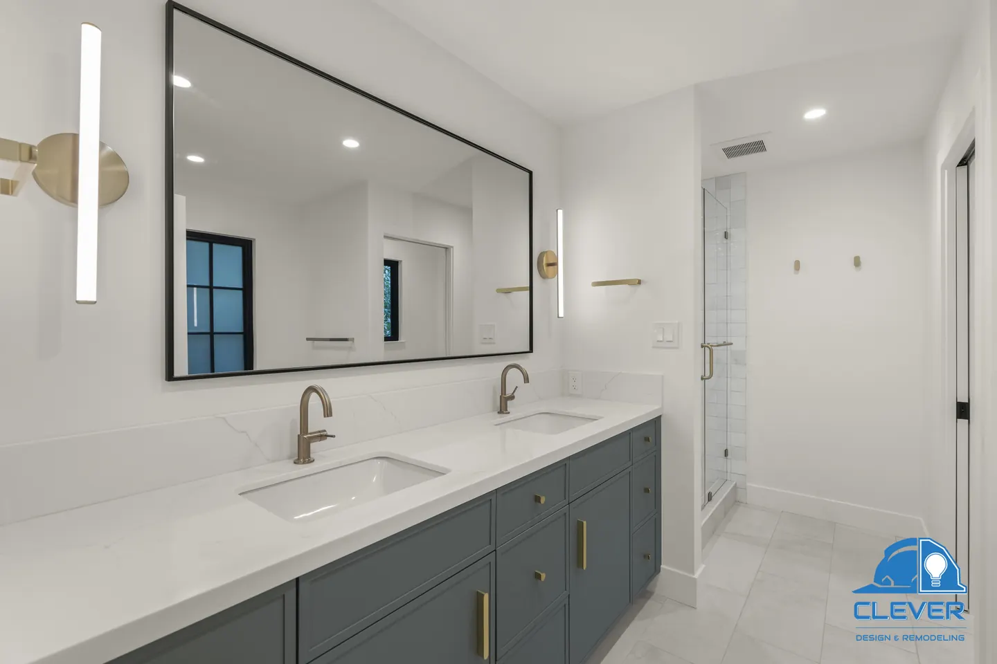 Primary bath with a navy double vanity, white quartz, brass faucets and a black-framed mirror, whole-home remodel in Saratoga, CA
