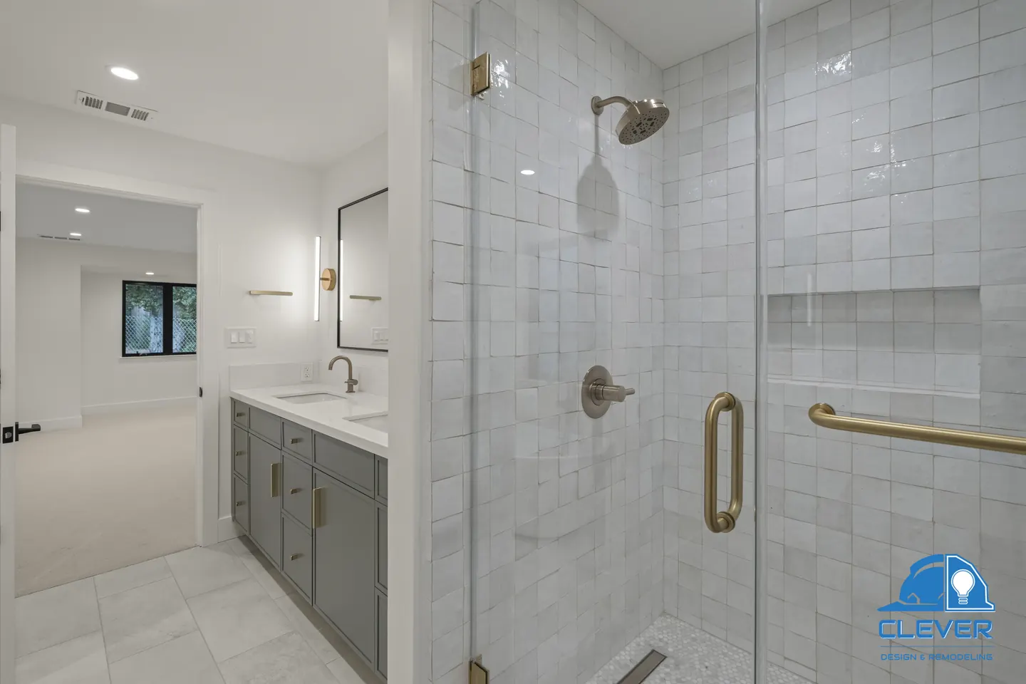 Glass walk-in shower in handmade-look white tile with brass fixtures and a linear drain, whole-home remodel in Saratoga, CA